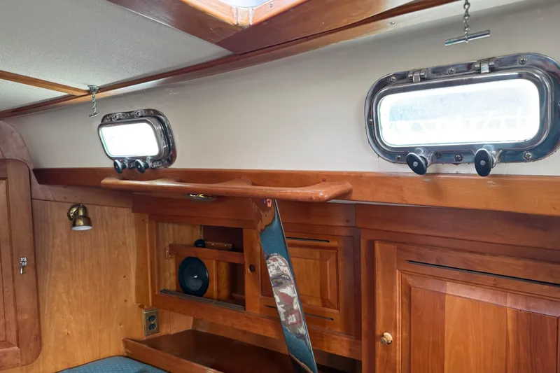Slide: The Image of Interior of a 2000 Tartan 3700 sailboat with wooden cabinetry and portholes. - 10