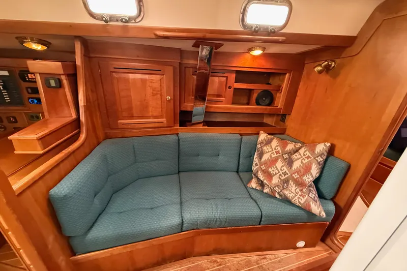 Slide: The Image of Cozy interior of 2000 Tartan 3700 yacht with blue cushioned seating and patterned pillow. - 11