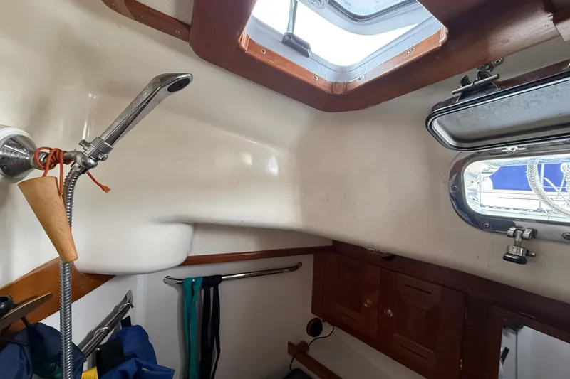 Slide: The Image of Interior of a 2000 Tartan 3700 sailboat bathroom with shower and porthole. - 26