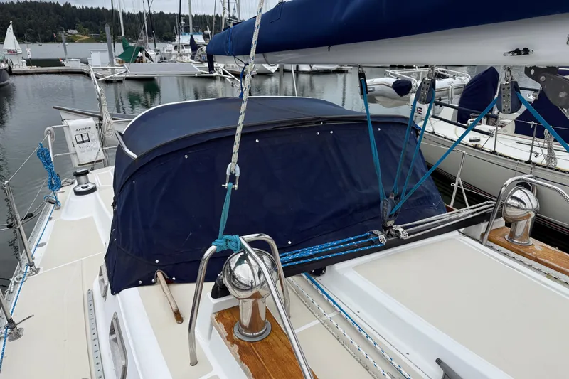 Slide: The Image of Tartan 3700 sailboat from 2000 docked in a marina, featuring a blue canopy. - 2