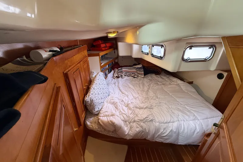 Slide: The Image of Cozy cabin interior of 2000 Tartan 3700 sailboat with bed and wooden storage. - 20