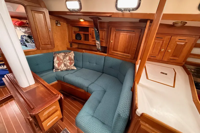 Slide: The Image of Cozy interior of a 2000 Tartan 3700 sailboat with blue seating and wooden cabinetry. - 12