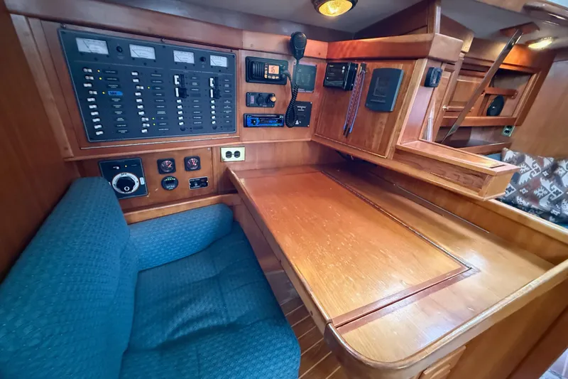 Slide: The Image of Navigation station of a 2000 Tartan 3700 yacht with control panels and seating. - 24