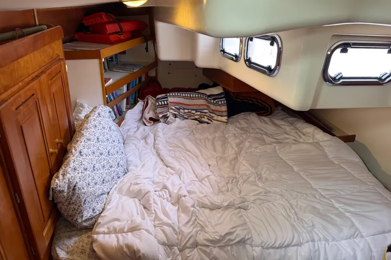 Slide: The Image of Cozy cabin interior of 2000 Tartan 3700 sailboat with bed, pillows, and bookshelves. - 22