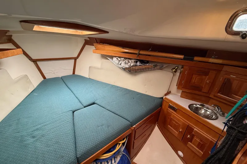 Slide: The Image of Cozy cabin interior of a 2000 Tartan 3700 sailboat with wooden cabinetry and a small sink. - 13