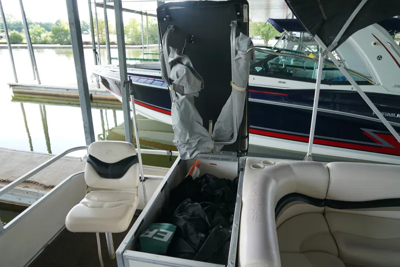 Slide: The Image of 2005 Sun Tracker Fishin' Barge 21 interior with storage compartment open at marina. - 16