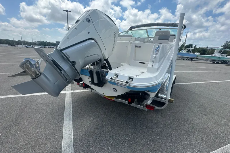 Slide: The Image of 2026 Sailfish 236 DC boat with powerful outboard motor in a parking lot. - 15