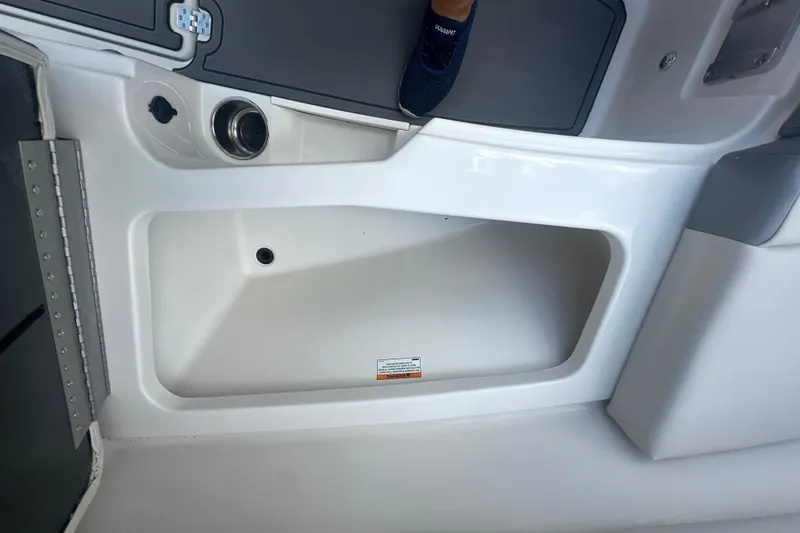 Slide: The Image of Interior view of 2026 Sailfish 236 DC boat, featuring storage compartment and cup holder. - 22