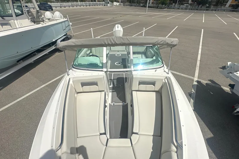 Slide: The Image of 2026 Sailfish 236 DC boat with spacious seating, parked in a lot under sunlight. - 16