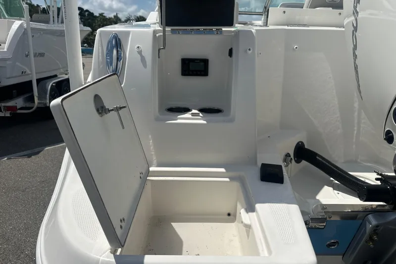 Slide: The Image of 2026 Sailfish 236 DC boat interior with open storage compartment and control panel. - 19