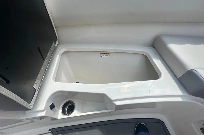 Slide: The Image of Open storage compartment on 2026 Sailfish 236 DC boat, featuring sleek white interior design. - 23