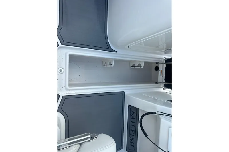 Slide: The Image of 2026 Sailfish 236 DC boat interior storage compartment with sleek design and branding. - 21