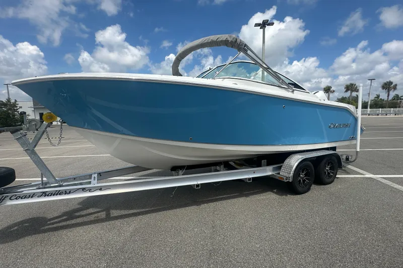 Slide: The Image of 2026 Sailfish 236 DC boat on trailer under a partly cloudy sky. - 10