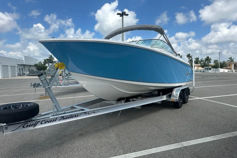 Slide: The Image of 2026 Sailfish 236 DC boat on trailer in sunny parking lot. - 11