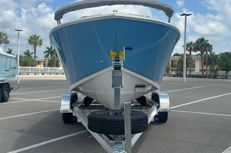 Slide: The Image of 2026 Sailfish 236 DC boat on trailer in parking lot, palm trees in background. - 12