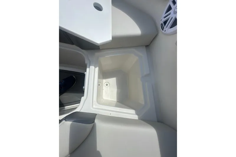 Slide: The Image of Interior view of 2026 Sailfish 236 DC boat, featuring storage compartment and speaker. - 26