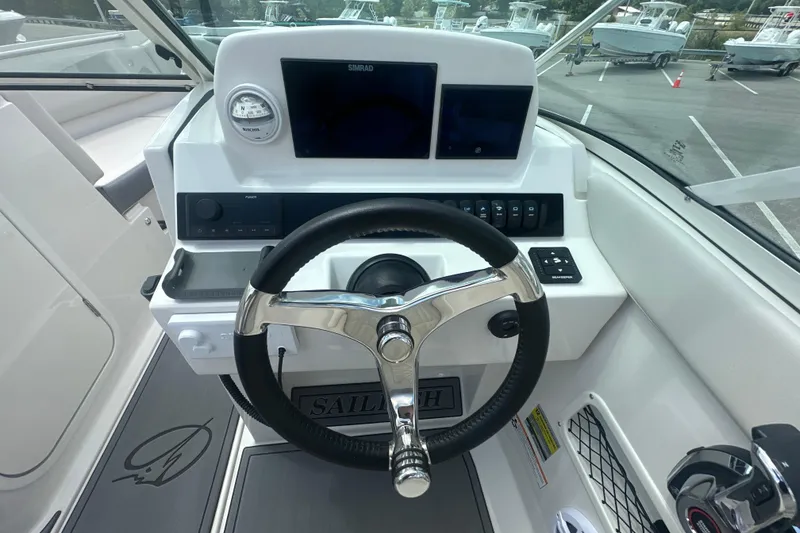 Slide: The Image of 2026 Sailfish 236 DC boat dashboard with steering wheel and navigation controls. - 32