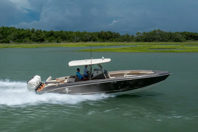 Slide: The Image of 2015 Statement 380 Open boat cruising on a scenic waterway with lush greenery. - 4