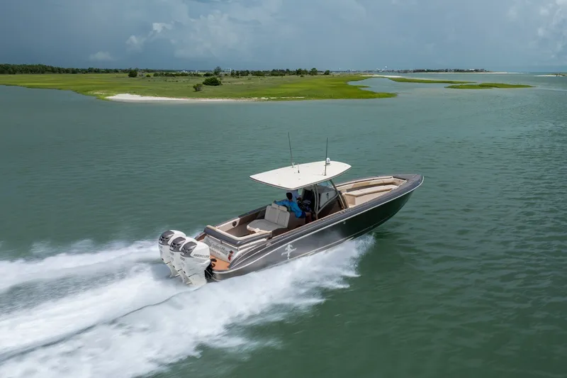 Slide: The Image of A 2015 Statement 380 Open boat cruising on a scenic waterway with lush green islands. - 12
