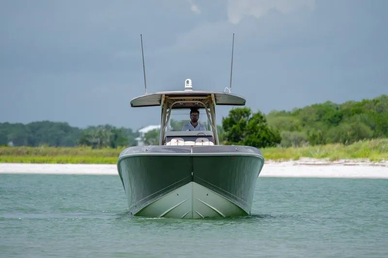 Slide: The Image of Front view of a 2015 Statement 380 Open boat on calm water near a sandy shore. - 13