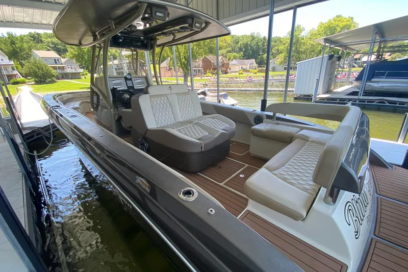 Slide: The Image of 2015 Statement 380 Open boat docked, featuring luxurious seating and modern controls. - 2