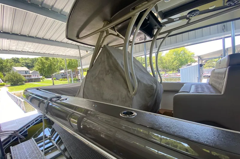 Slide: The Image of 2015 Statement 380 Open boat docked under a canopy, showcasing interior seating and structure. - 11