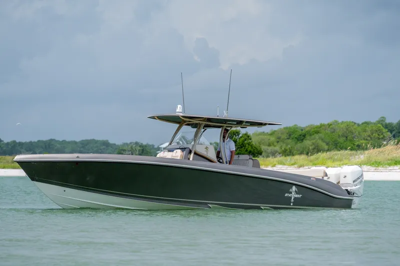 Slide: The Image of 2015 Statement 380 Open boat cruising on calm water near a lush shoreline. - 18