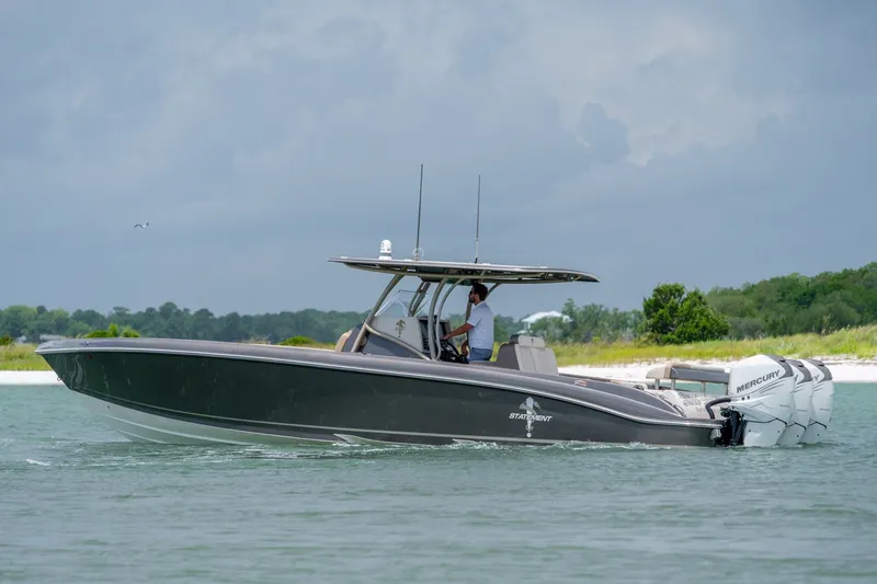 Slide: The Image of 2015 Statement 380 Open boat cruising on water with Mercury engines, scenic background. - 20