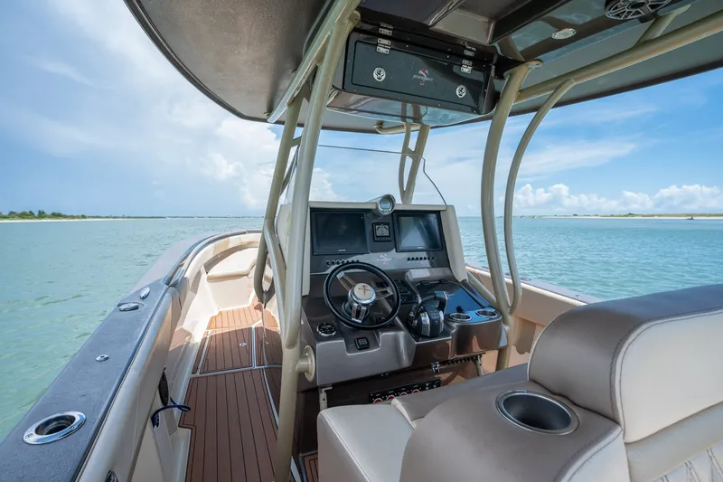 Slide: The Image of Interior view of 2015 Statement 380 Open boat, featuring helm and seating on calm water. - 25