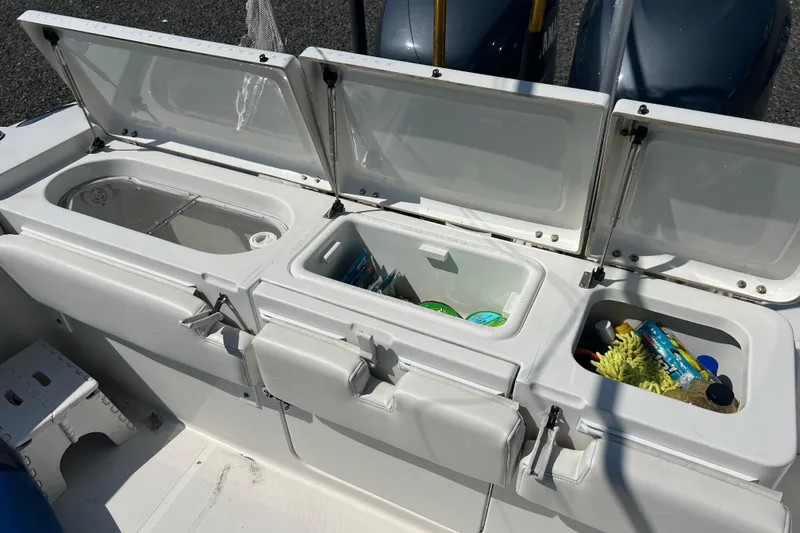 Slide: The Image of Open storage compartments on a 2002 Triton 2895 CC boat, showcasing organized gear and supplies. - 18