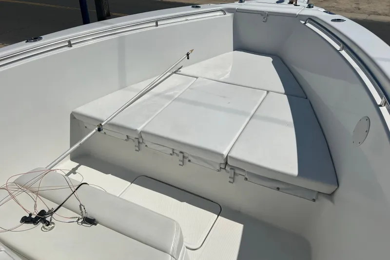 Slide: The Image of 2002 Triton 2895 CC boat interior with cushioned seating and fishing rod holder. - 4