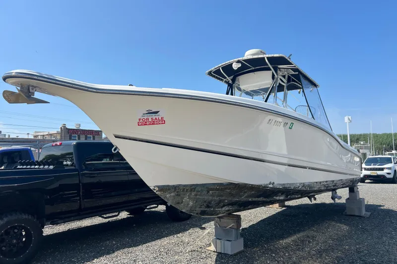 The Image of 2002 Triton 2895 CC boat for sale, elevated on blocks, with a clear blue sky background. - 0