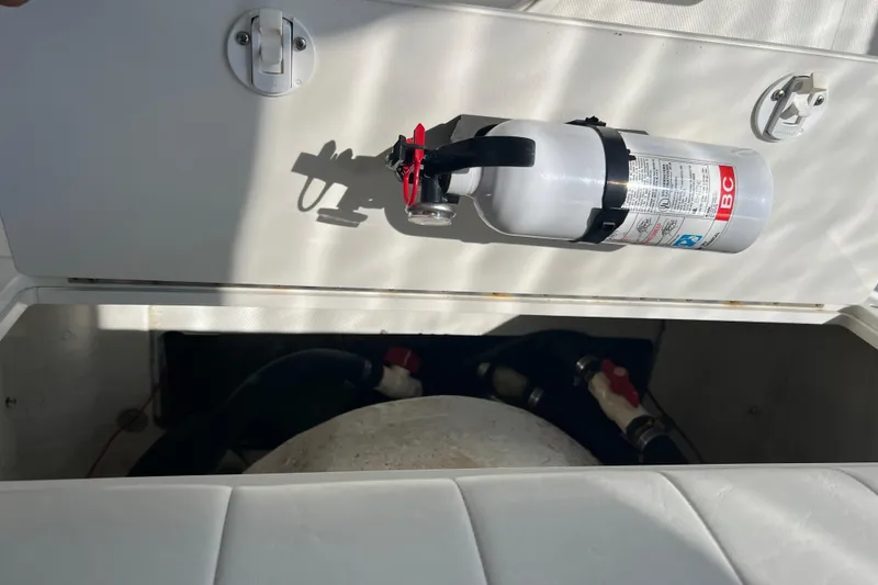 Slide: The Image of Fire extinguisher mounted on a 2002 Triton 2895 CC boat compartment. - 19