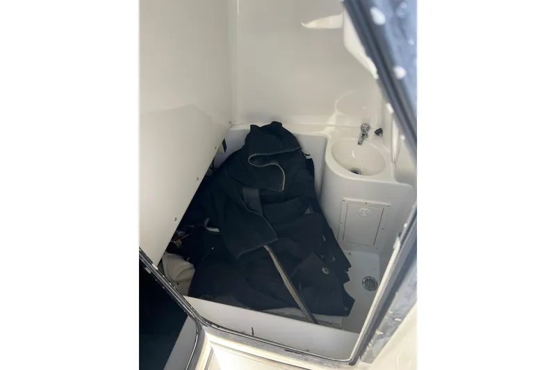 Slide: The Image of Interior of 2002 Triton 2895 CC boat with sink and storage area. - 15