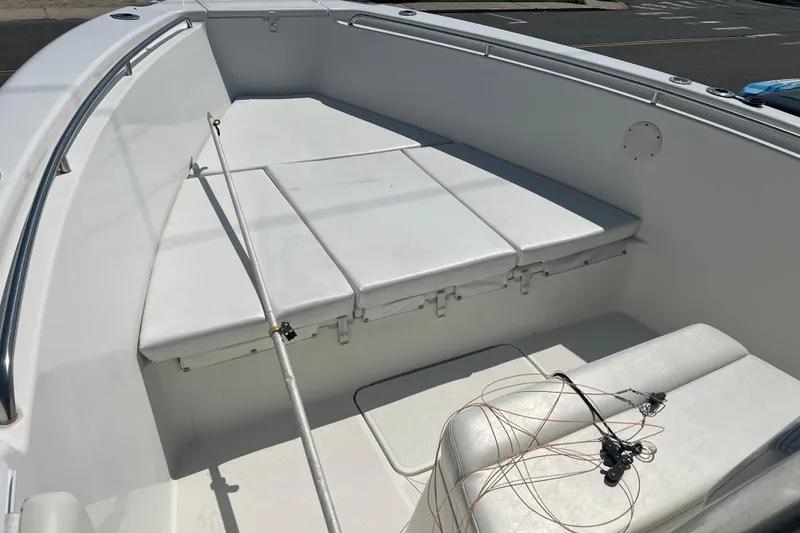 Slide: The Image of 2002 Triton 2895 CC boat interior with white seating and fishing rod. - 3
