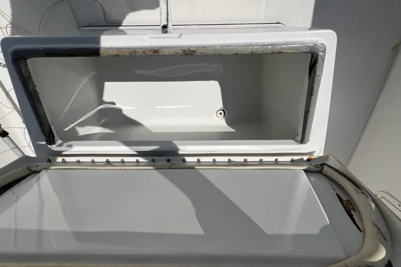 Slide: The Image of Open storage compartment on a 2002 Triton 2895 CC boat, showing interior details. - 10