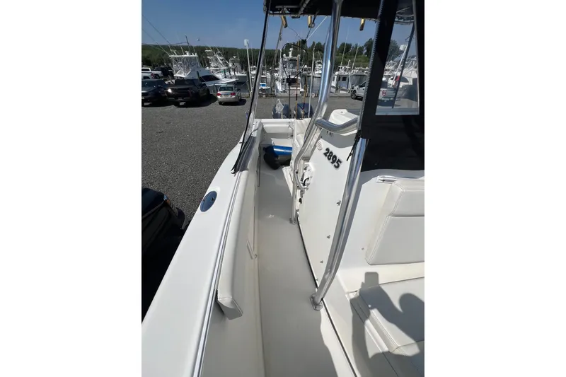 Slide: The Image of 2002 Triton 2895 CC boat interior with seating and console, docked at marina. - 11