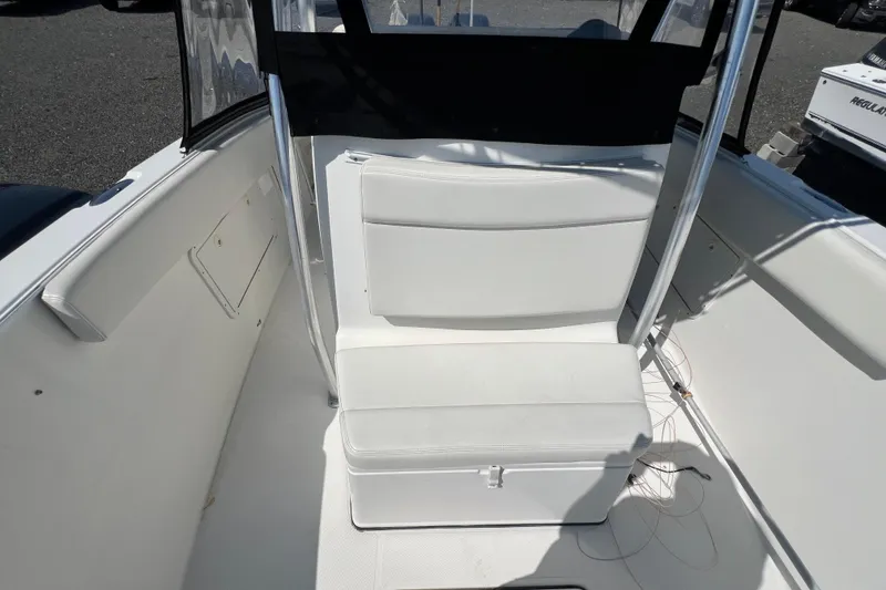 Slide: The Image of 2002 Triton 2895 CC boat interior with white seating and storage compartment. - 9