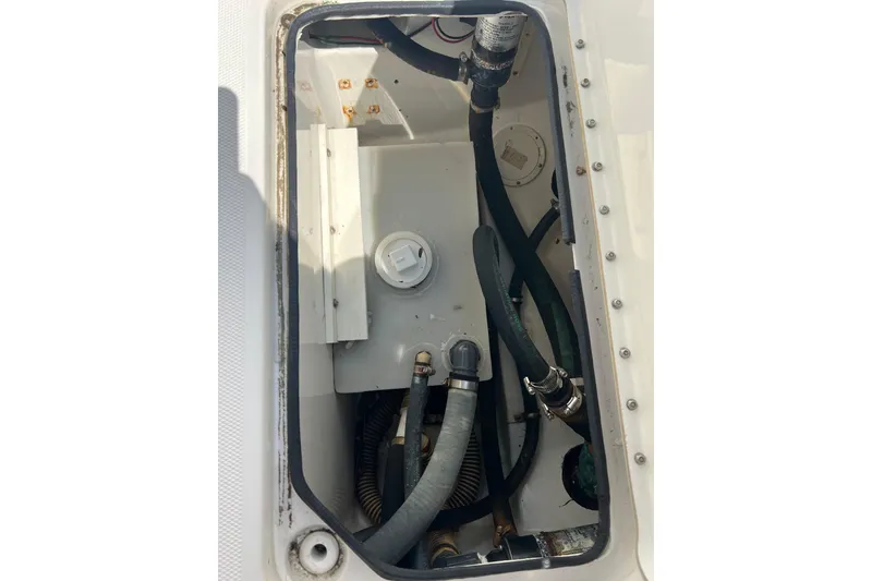 Slide: The Image of 2002 Triton 2895 CC boat compartment with hoses and fittings. - 8