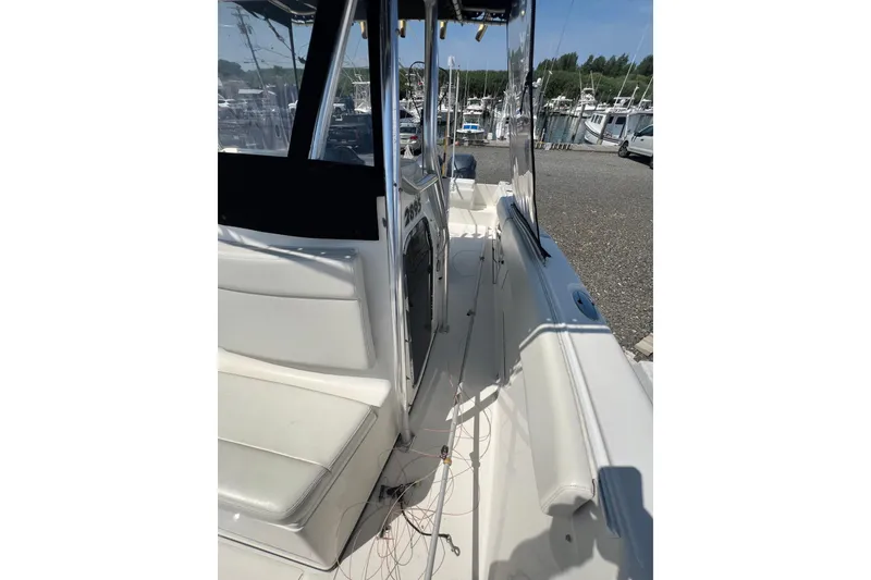 Slide: The Image of 2002 Triton 2895 CC boat interior with seating and console, docked at marina. - 12