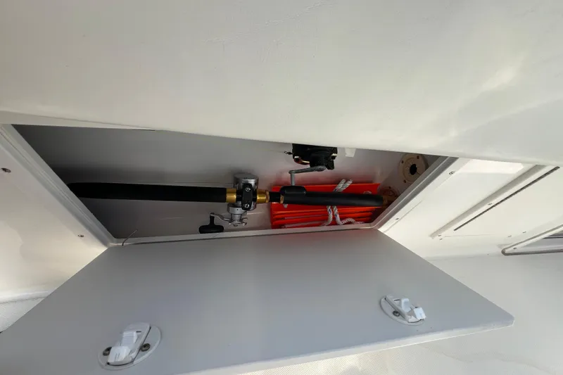 Slide: The Image of Storage compartment on a 2002 Triton 2895 CC boat, featuring equipment and accessories. - 13