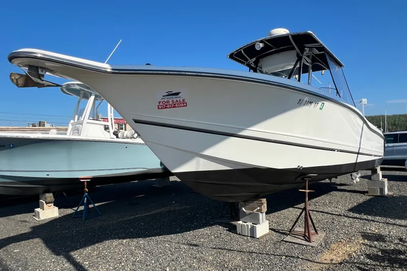 Slide: The Image of 2002 Triton 2895 CC boat for sale, displayed on stands in a marina. - 1