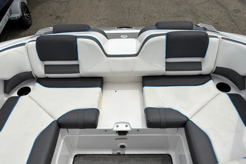 Slide: The Image of 2020 Yamaha Boats AR210 interior seating with white and gray upholstery, featuring blue accents. - 7
