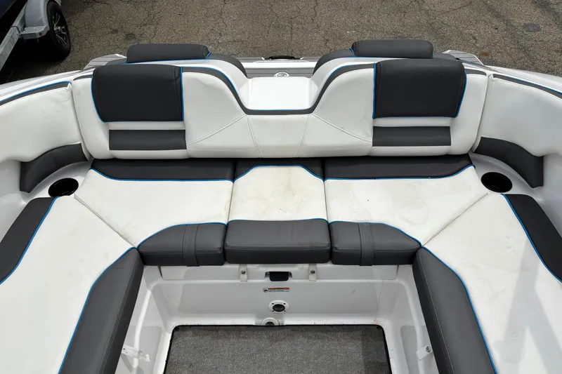 Slide: The Image of 2020 Yamaha Boats AR210 interior seating with white and black upholstery, featuring blue accents. - 6