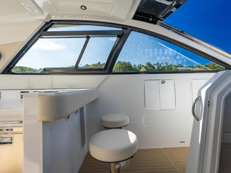 Slide: The Image of Interior view of a modern yacht with white seating and large windows showing a clear sky. - 49
