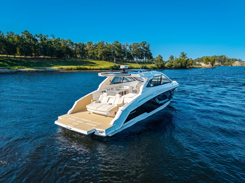 Slide: The Image of The 2027 Cruisers Yachts 42 GLS is a sleek boat on a calm lake. - 15