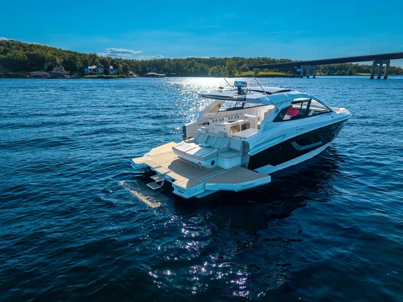 Slide: The Image of The 2027 Cruisers Yachts 42 GLS is on calm waters with a bridge in the background. - 21