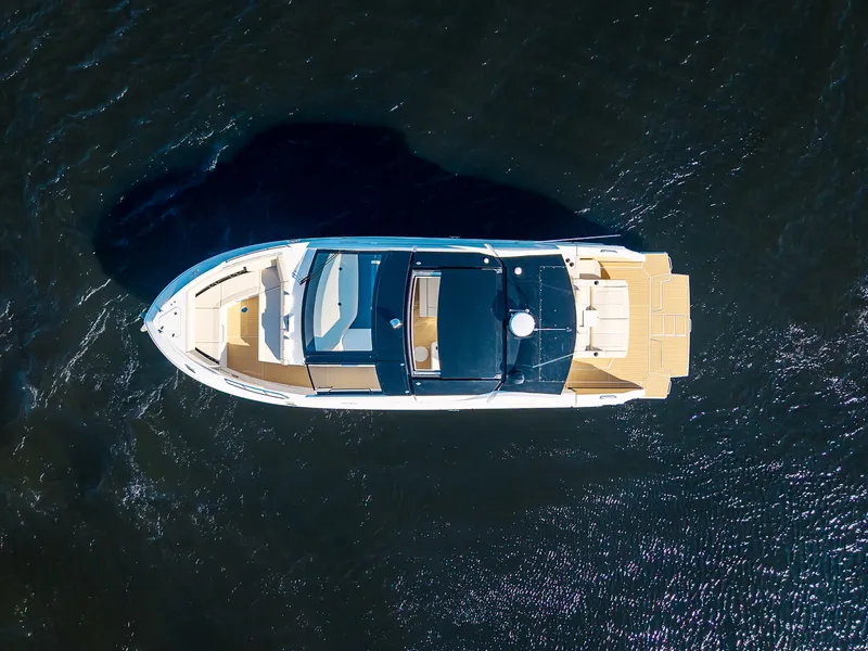 Slide: The Image of Aerial view of a 2027 Cruisers Yachts 42 GLS on calm water. - 2