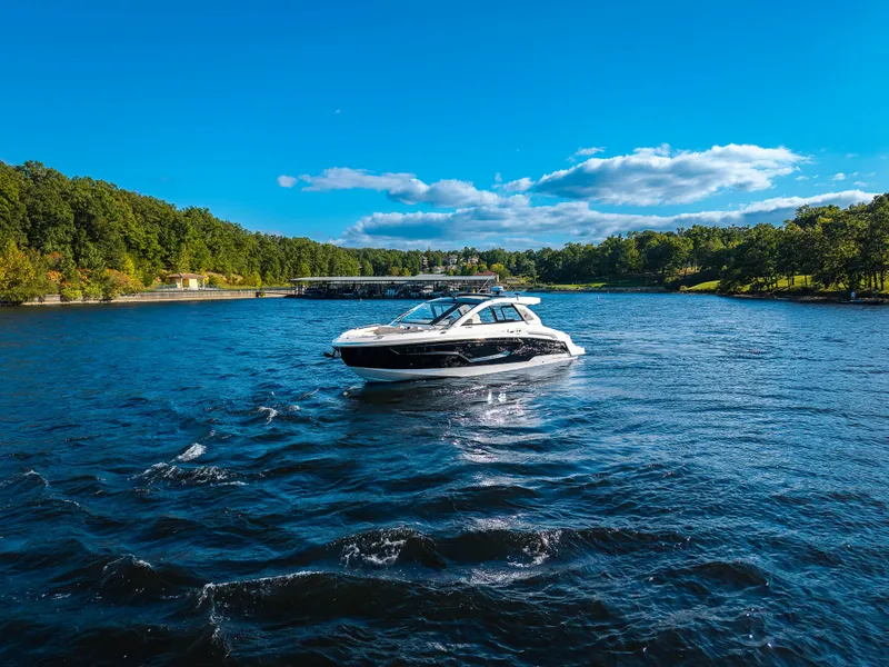 Slide: The Image of The 2027 Cruisers Yachts 42 GLS navigates a calm river, surrounded by lush greenery. - 11