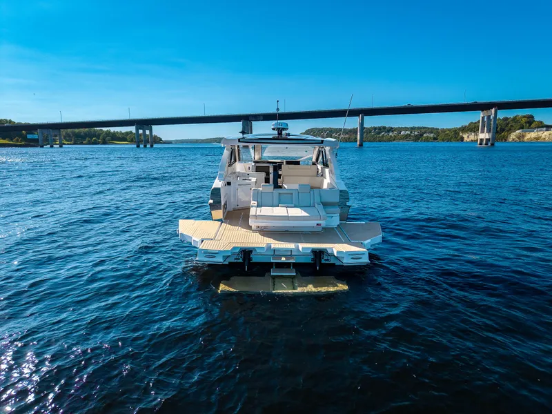 Slide: The Image of The 2027 Cruisers Yachts 42 GLS is on calm waters beneath a bridge. - 16